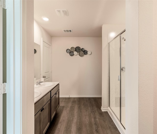 bathroom featuring wood-type flooring, vanity, and walk in shower