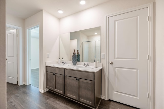 bathroom featuring hardwood / wood-style flooring, vanity, and a shower with door