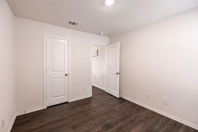 unfurnished bedroom featuring dark wood-type flooring