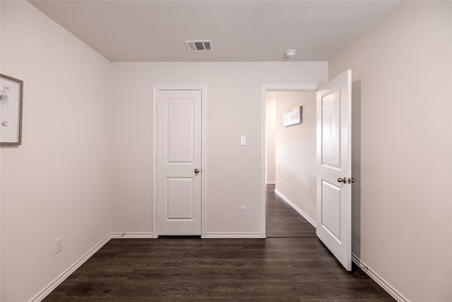 unfurnished bedroom with dark hardwood / wood-style flooring