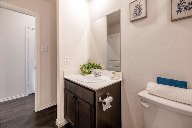 bathroom featuring wood-type flooring, vanity, and toilet