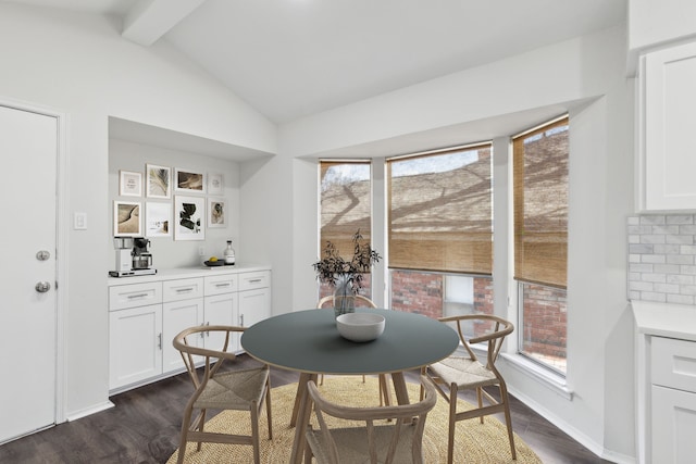 dining space featuring vaulted ceiling with beams and dark hardwood / wood-style floors