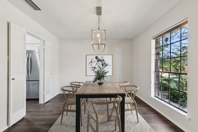 dining area with dark hardwood / wood-style flooring and a chandelier