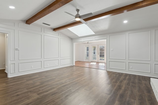 unfurnished living room featuring dark wood-type flooring, vaulted ceiling with skylight, ceiling fan, and french doors