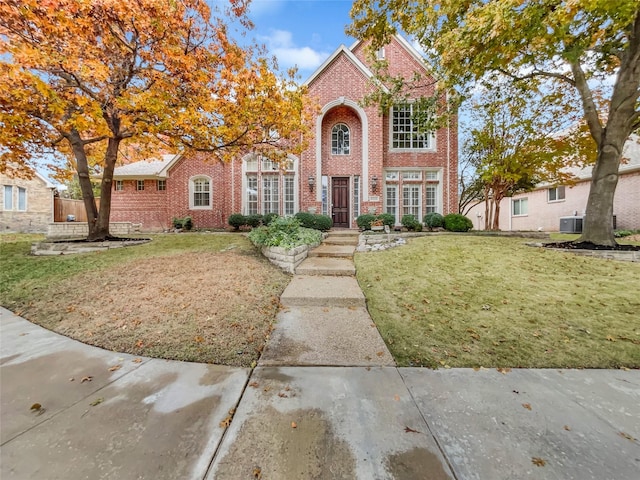 view of front of house with central AC and a front yard