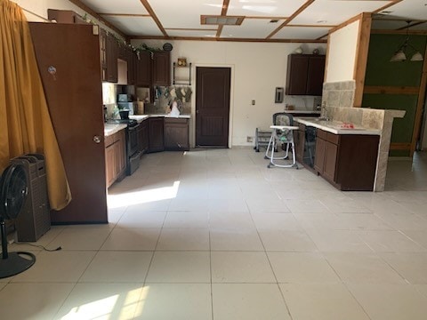 kitchen featuring light countertops, dark brown cabinets, and black electric range oven