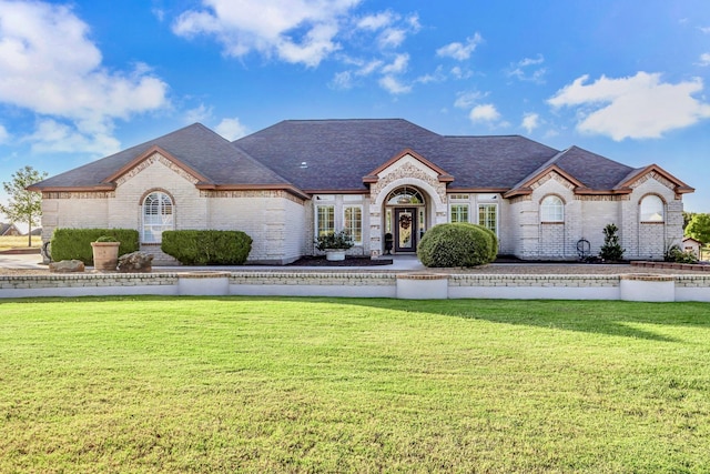 french country inspired facade featuring a front yard