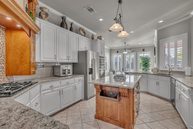 kitchen with white cabinetry, stainless steel appliances, a center island, and sink