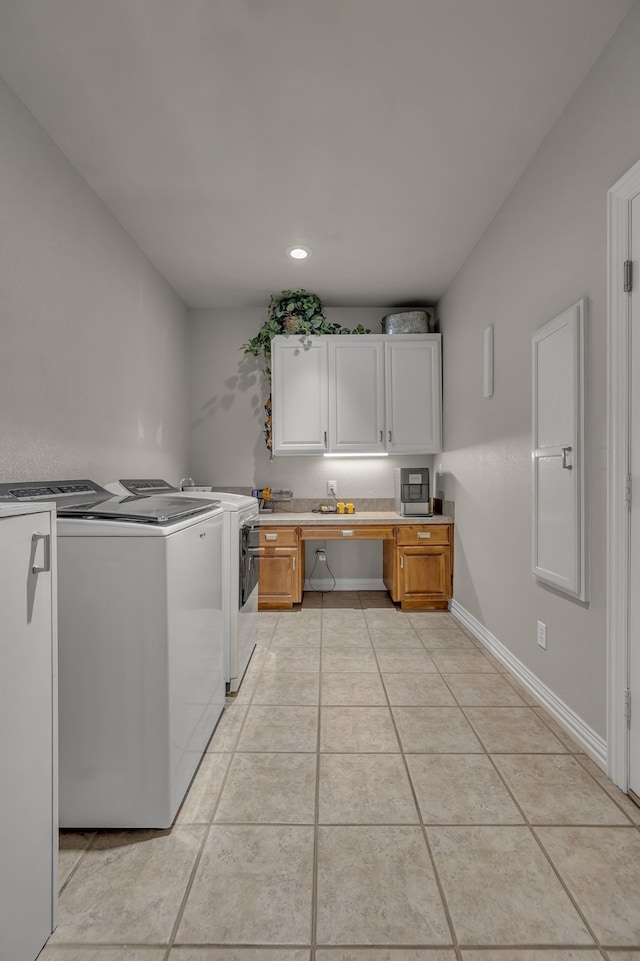 laundry room with washer and dryer and light tile patterned floors