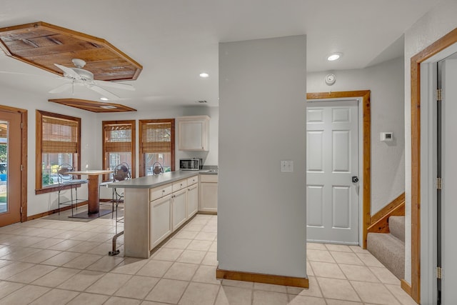 kitchen with a kitchen island, a kitchen breakfast bar, ceiling fan, and light tile patterned flooring