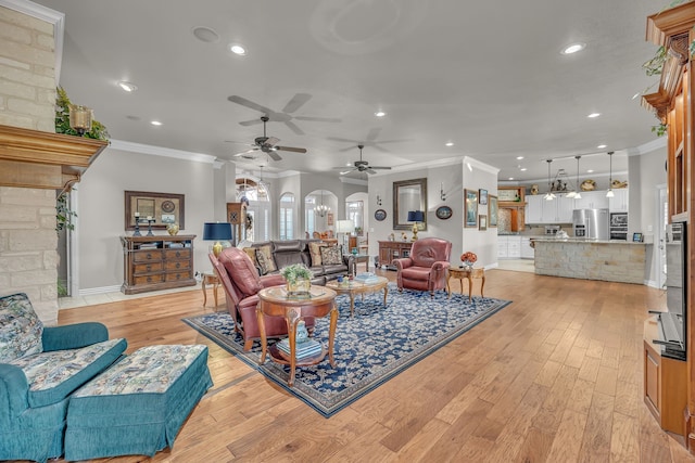 living room featuring crown molding, a chandelier, and light wood-type flooring