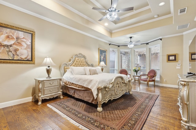 bedroom featuring ceiling fan, ornamental molding, a raised ceiling, and hardwood / wood-style floors