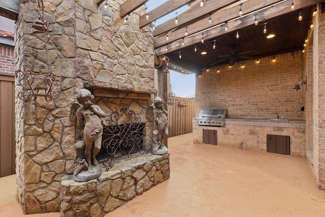 view of patio / terrace featuring an outdoor kitchen, sink, area for grilling, ceiling fan, and an outdoor stone fireplace