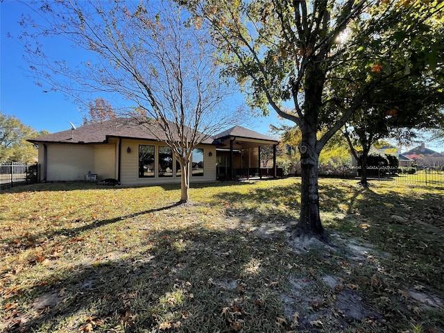 rear view of house featuring a lawn