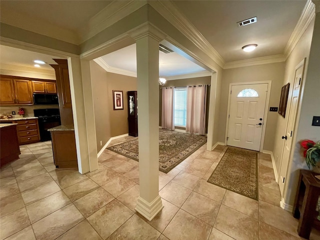 foyer entrance with decorative columns, crown molding, and light tile patterned floors