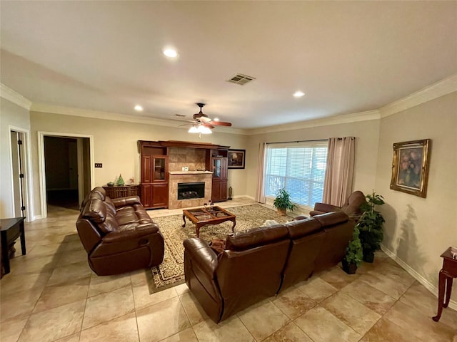 living room featuring a tile fireplace, ornamental molding, and ceiling fan