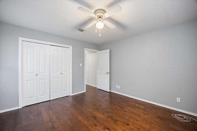 unfurnished bedroom with ceiling fan, dark hardwood / wood-style flooring, and a closet