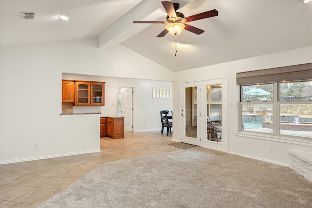 unfurnished living room with light tile patterned flooring, vaulted ceiling with beams, and ceiling fan