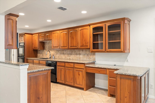 kitchen featuring light stone countertops, decorative backsplash, and black appliances