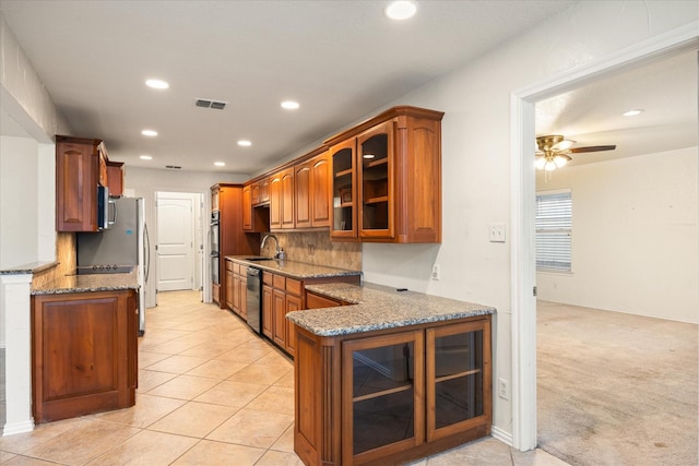 kitchen featuring light stone counters, double wall oven, dishwasher, and sink