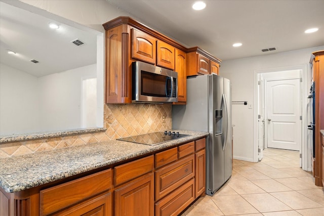 kitchen with light stone counters, stainless steel appliances, light tile patterned flooring, and tasteful backsplash