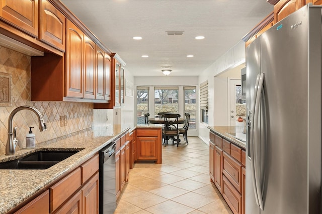 kitchen featuring light tile patterned flooring, sink, light stone counters, stainless steel fridge with ice dispenser, and black dishwasher