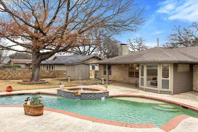 view of swimming pool featuring a patio, a storage unit, pool water feature, and an in ground hot tub