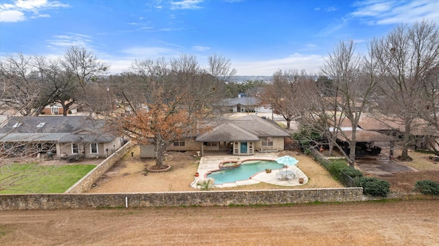 rear view of property with a fenced in pool and a patio area