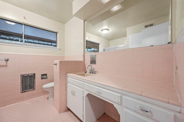 bathroom featuring vanity, tile patterned floors, toilet, and tile walls