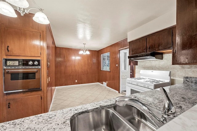 kitchen featuring wall oven, decorative light fixtures, white gas stove, and a notable chandelier