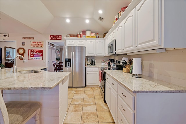 kitchen featuring stainless steel appliances, white cabinetry, light stone countertops, and sink