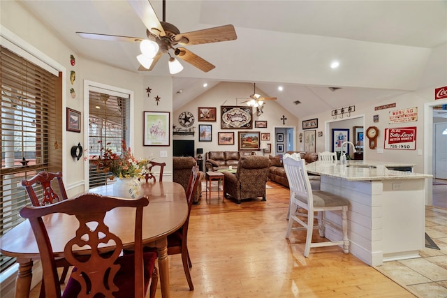 dining area with vaulted ceiling, sink, ceiling fan, and light hardwood / wood-style floors