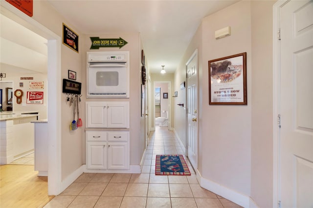 hall with light tile patterned floors