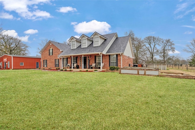 view of front of property featuring covered porch, brick siding, a shingled roof, fence, and a front lawn