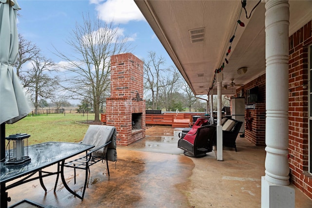 view of patio with an outdoor brick fireplace and ceiling fan