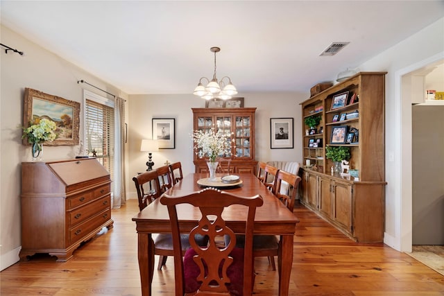 dining area featuring an inviting chandelier and light hardwood / wood-style flooring