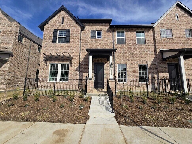 view of front of property with brick siding and a fenced front yard