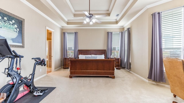 bedroom with ensuite bathroom, ceiling fan, a raised ceiling, crown molding, and light carpet