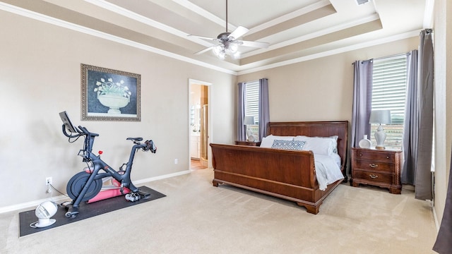 carpeted bedroom featuring a raised ceiling, crown molding, connected bathroom, and ceiling fan