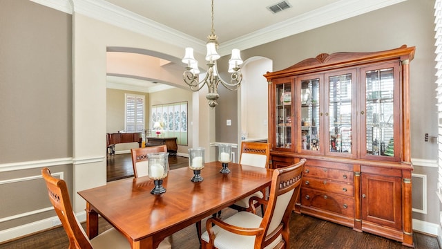 dining area with crown molding, dark hardwood / wood-style flooring, and a notable chandelier