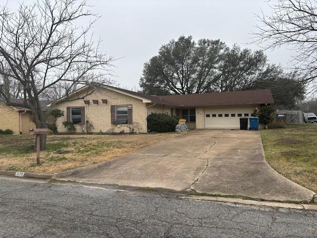 ranch-style home featuring a garage and a front lawn