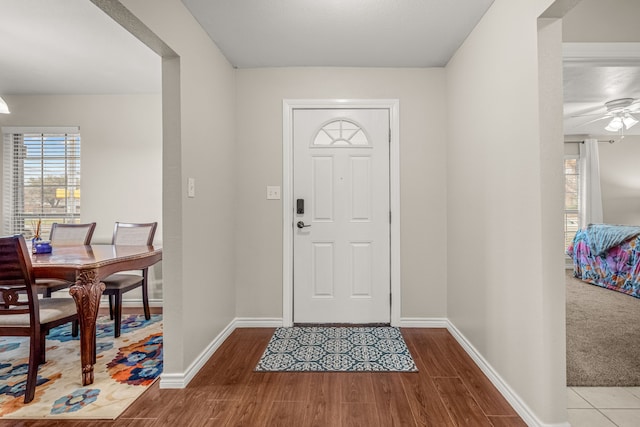 foyer entrance with ceiling fan and light wood-type flooring