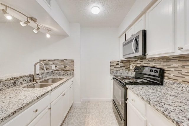 kitchen with black electric range oven, sink, white cabinetry, light stone counters, and a textured ceiling