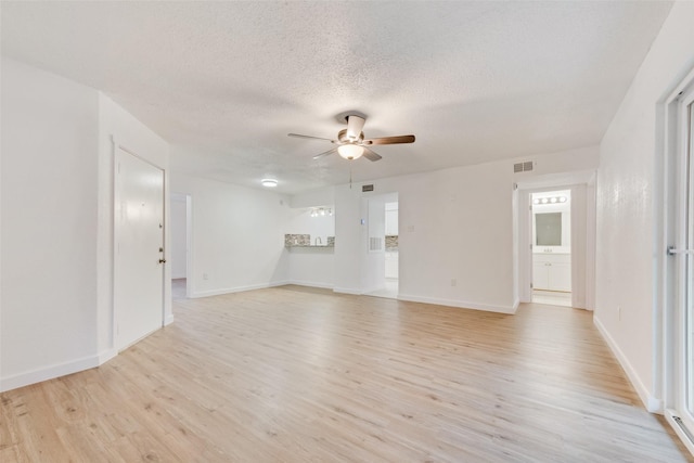 spare room with ceiling fan, light hardwood / wood-style flooring, and a textured ceiling