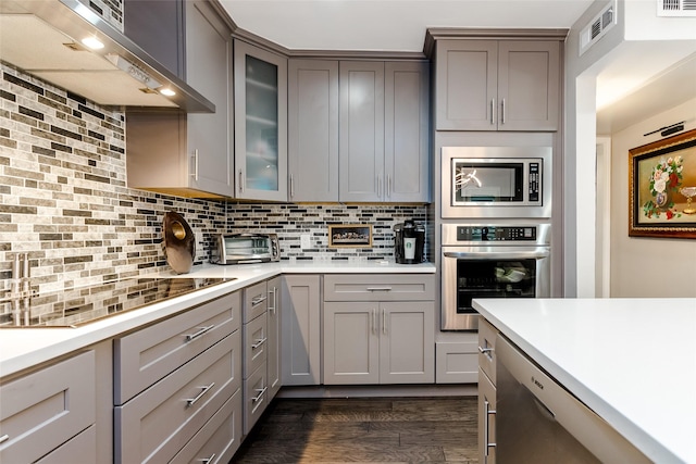 kitchen with stainless steel appliances, dark hardwood / wood-style flooring, range hood, and backsplash