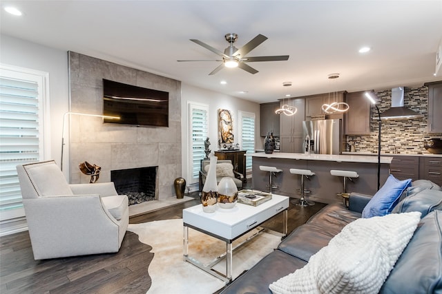 living room featuring a high end fireplace, dark hardwood / wood-style floors, and ceiling fan