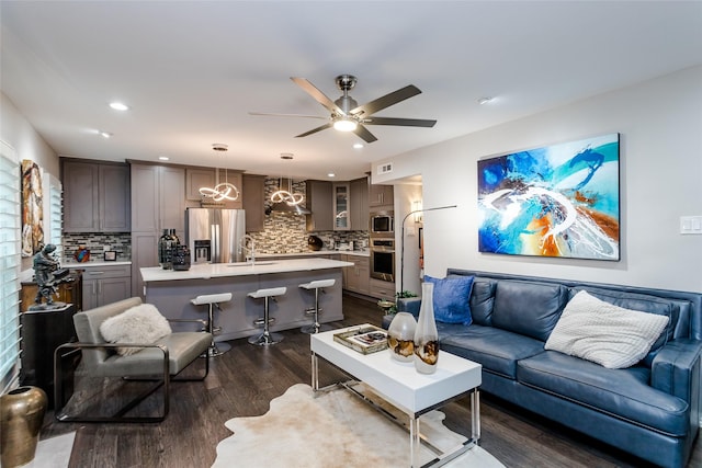 living room with sink, dark wood-type flooring, and ceiling fan