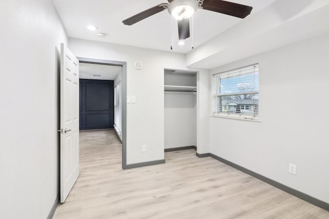 unfurnished bedroom featuring ceiling fan, a closet, and light hardwood / wood-style flooring