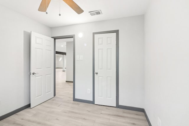 unfurnished bedroom with ceiling fan and light wood-type flooring