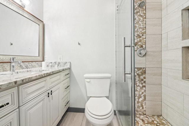 bathroom featuring vanity, an enclosed shower, and toilet